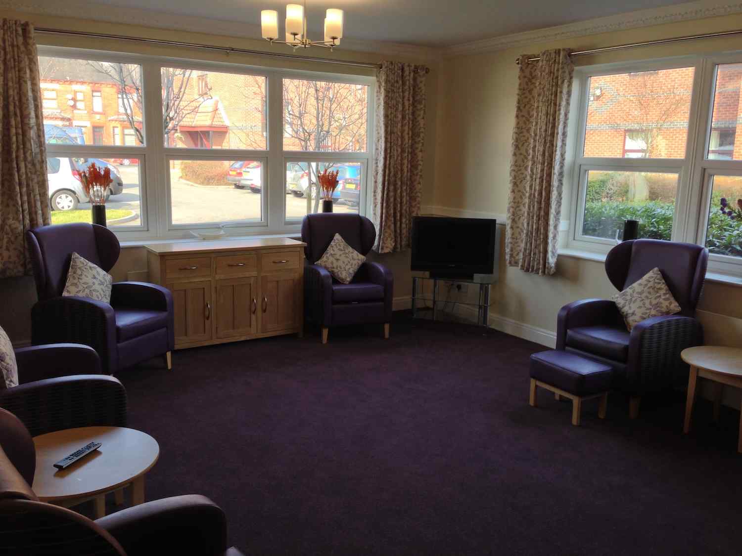 living room area with purple armchairs around the outside